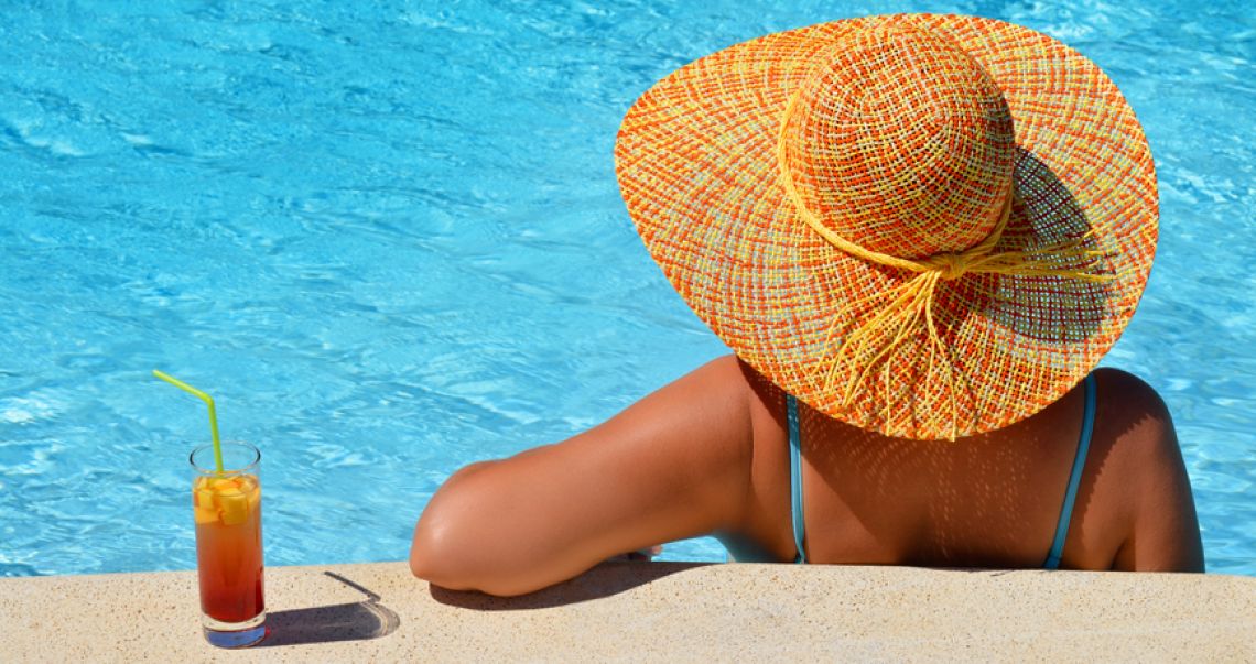Woman enjoying drink by the pool